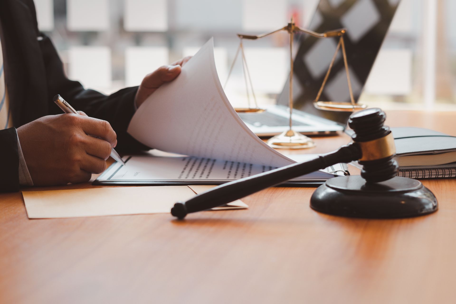 A judge is sitting at a desk with a gavel and scales of justice.