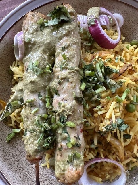 A close up of a plate of food with rice and meat