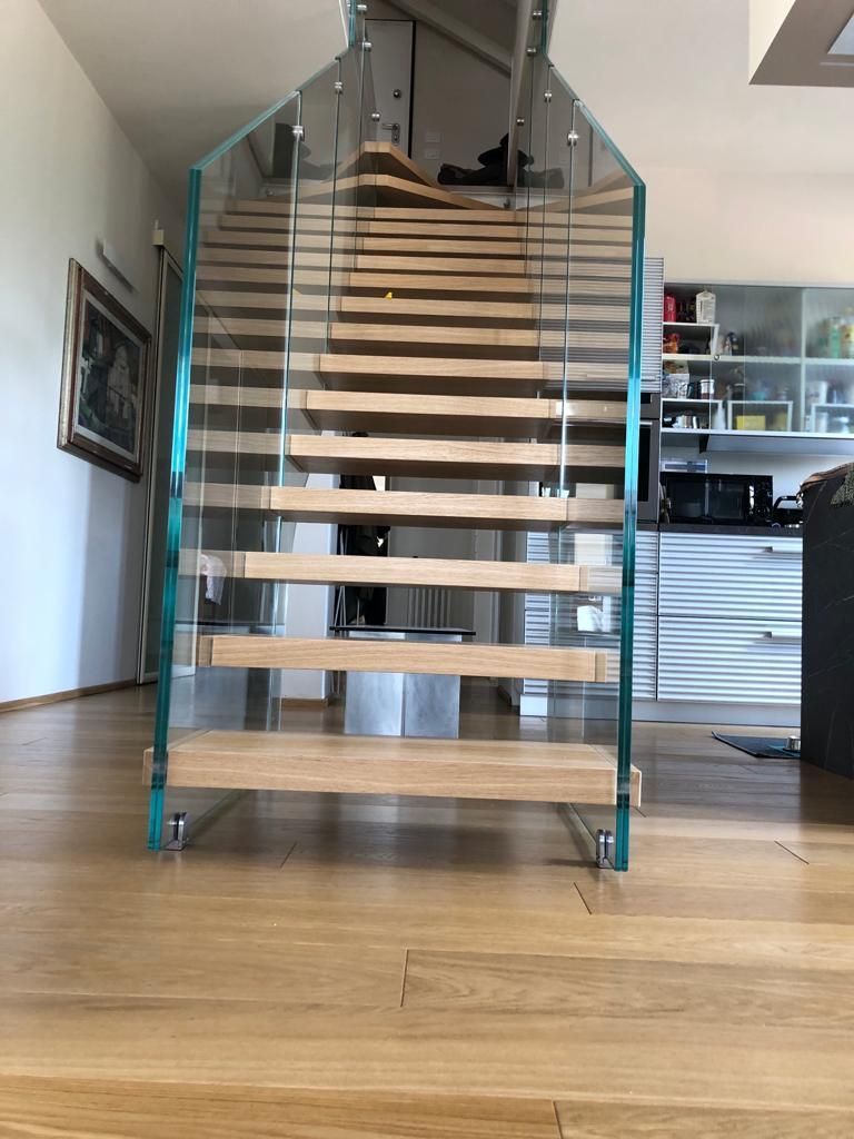 Una levigatrice a nastro largo con due teste di levigatura lavora una lunga asse di legno in un'officina.