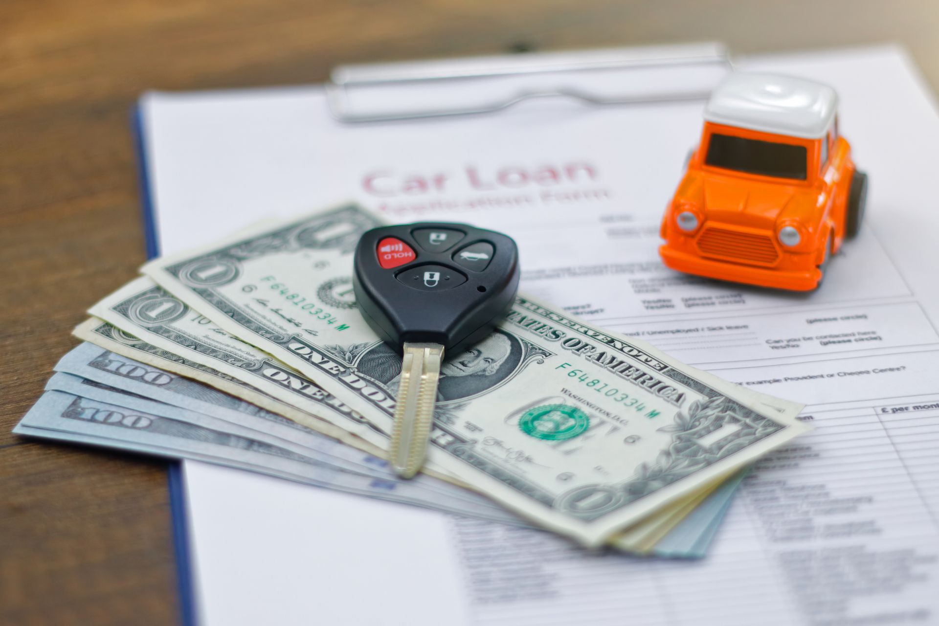 Car loan application with car keys and model car. Car loan application with car keys and model car.