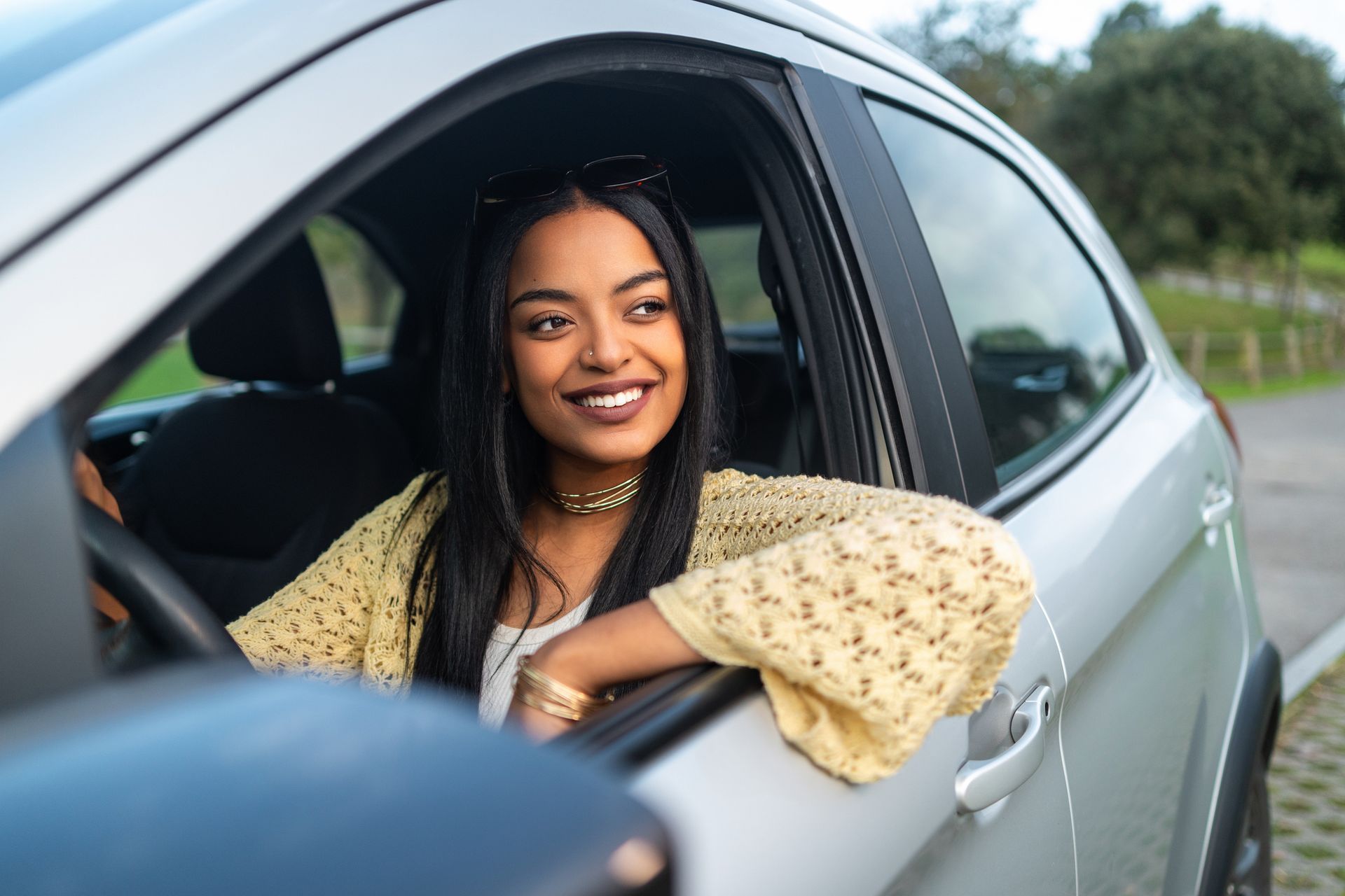 Person relaxing in car with arm casually resting out the window.