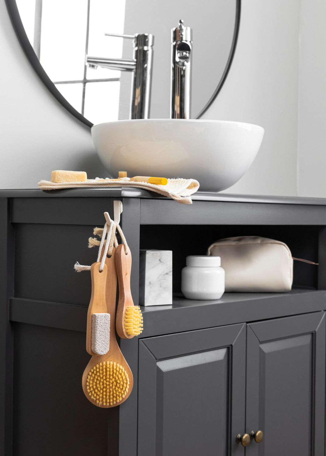 A bathroom vanity with a sink and brushes hanging from it.