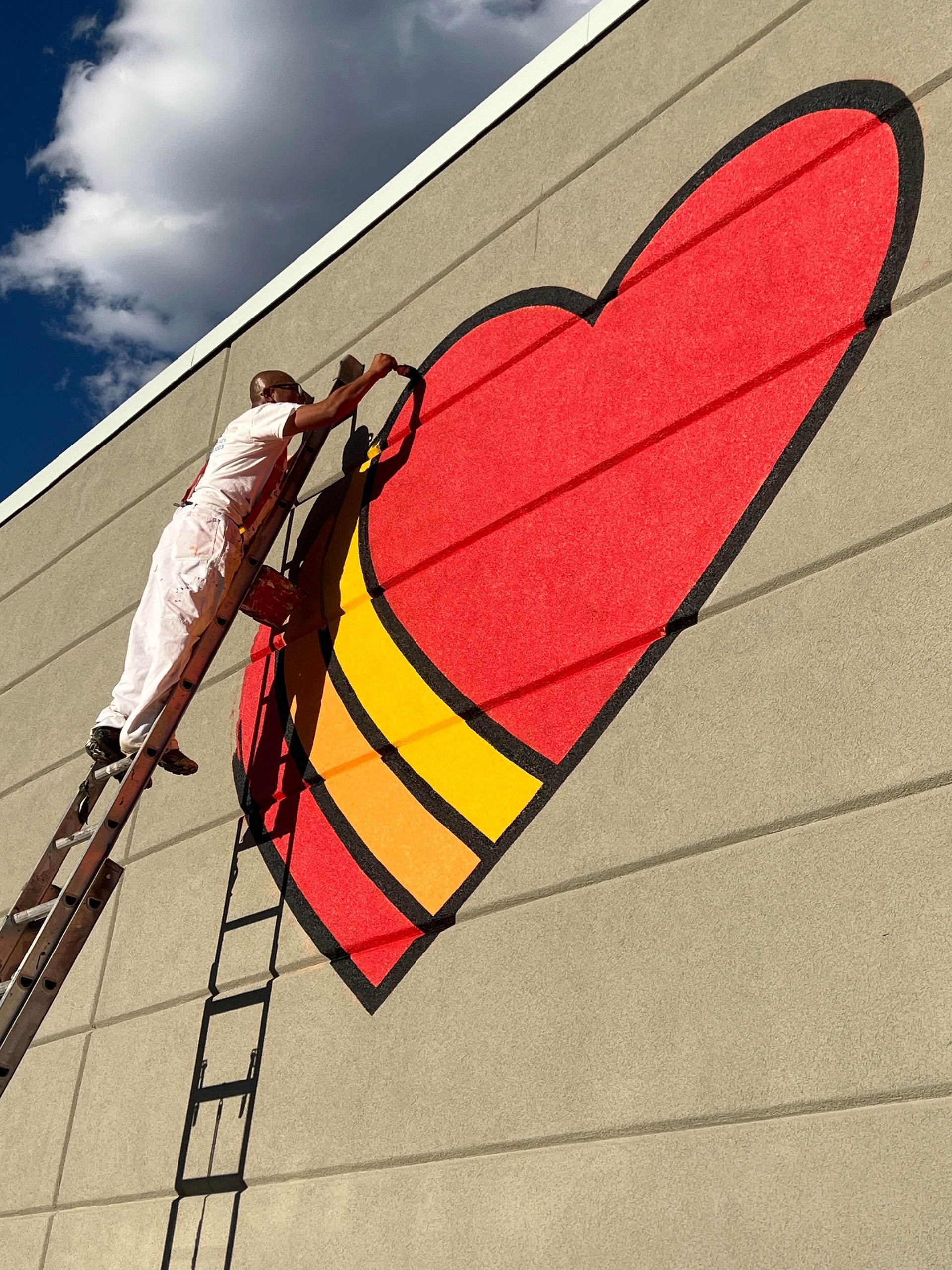 Artist paints a red heart on the wall