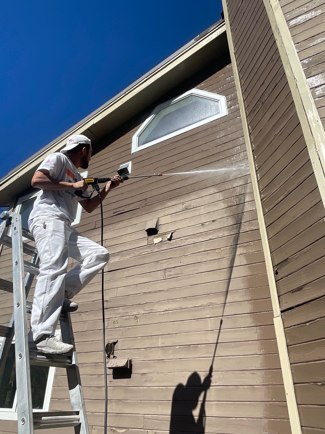 man painting house exterior