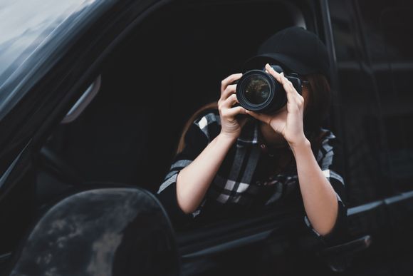 a woman is sitting in a car taking a picture with a camera
