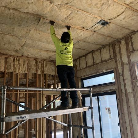 Man Installing Fiberglass Insulation — Colorado Springs, CO — Grand View Construction