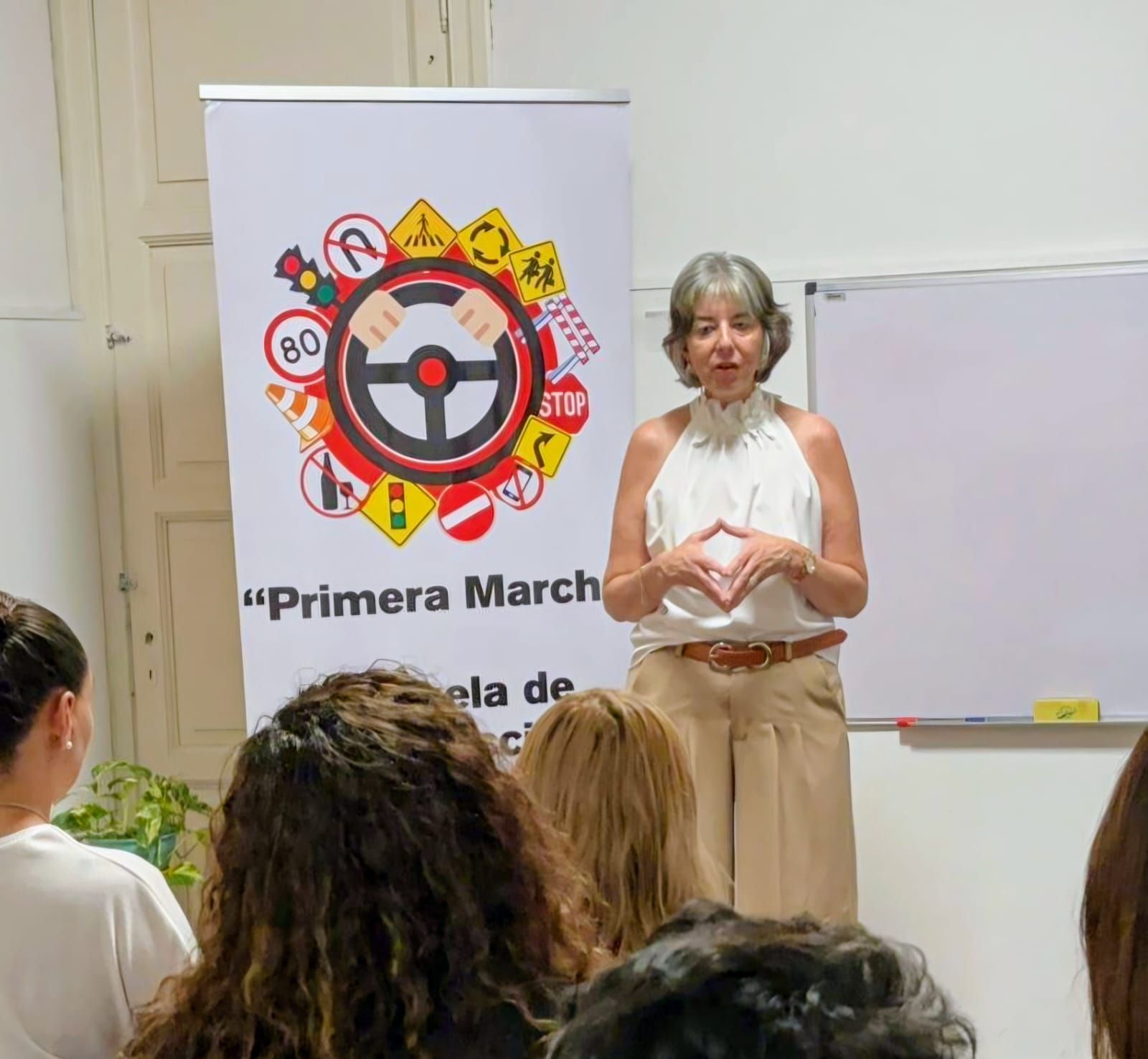 Grupo de personas con certificados, sonriendo en una sala. Camisas blancas, expresiones felices.