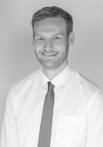 andy at sabre insurance in a white shirt and tie is smiling in a black and white photo .