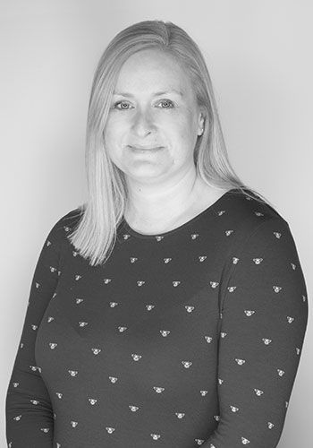 a black and white photo of jeanette at sabre insurance wearing a polka dot shirt .
