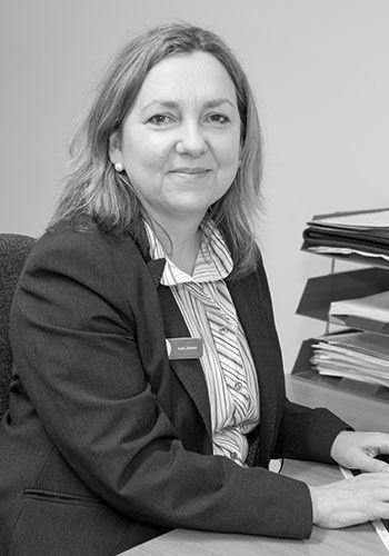 lou at sabre insurance in a suit is sitting at a desk in a black and white photo .