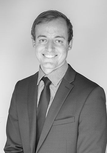 robert at sabre insurance in a suit and tie is smiling in a black and white photo .