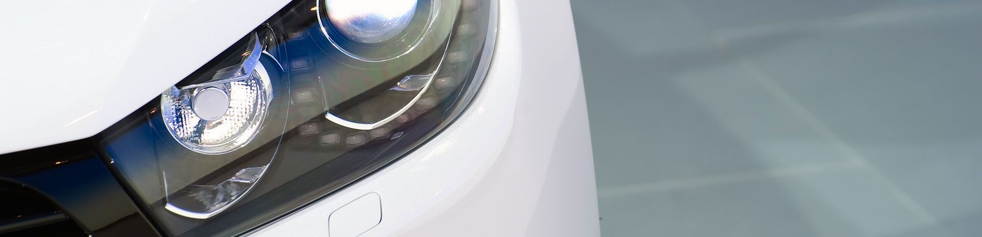 a close up of the headlights of a white car .