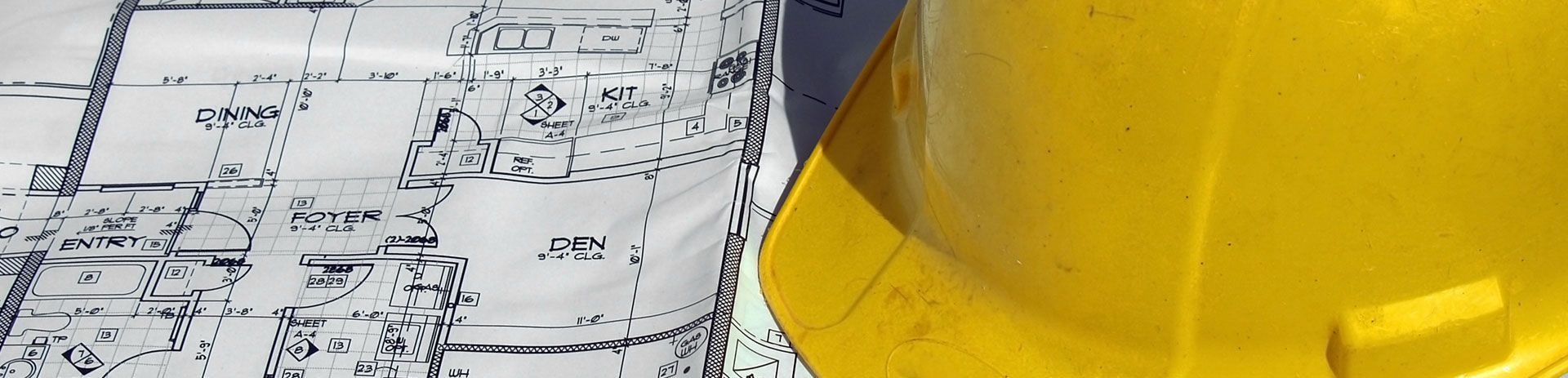 a yellow hard hat is sitting next to a blueprint .