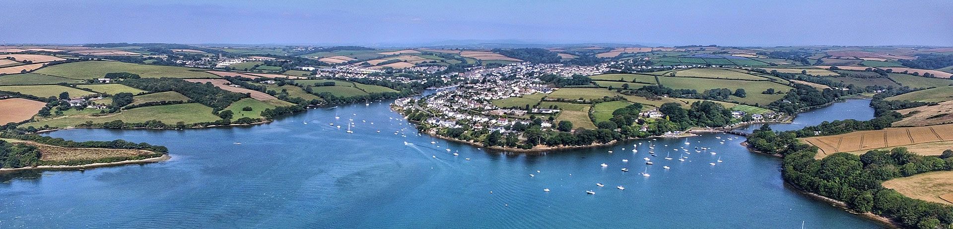 an aerial view of a large body of water surrounded by trees and fields at salcombe.