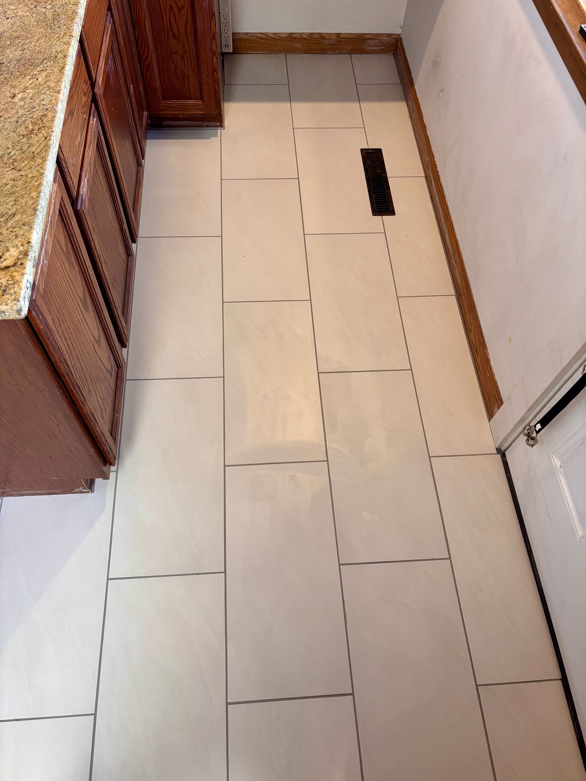 Tiled floor with dashed cutting lines, next to a cabinet and a doorway.