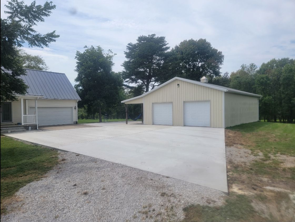 A garage with a concrete driveway in front of it