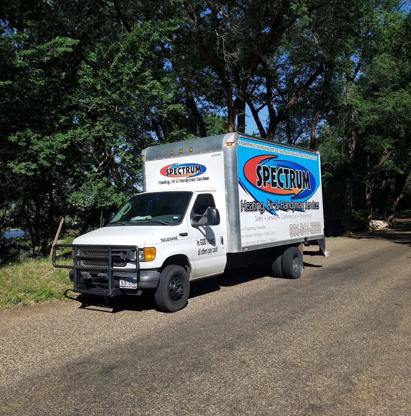 A spectrum truck is parked on the side of the road