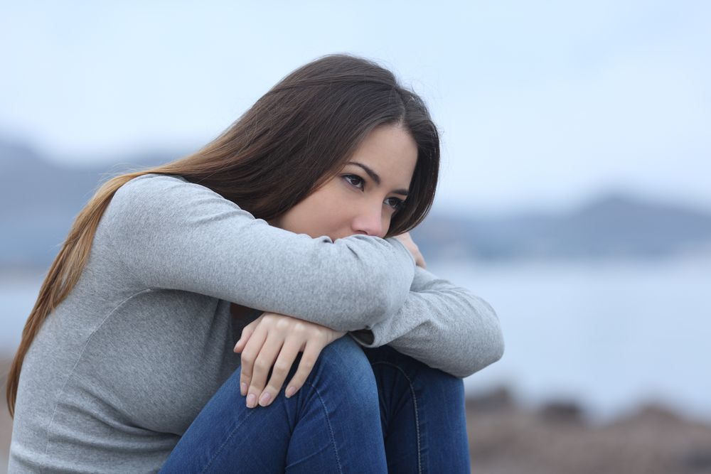 Sad woman sitting on the beach