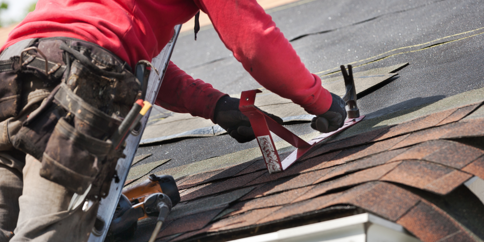 A man is working on the roof of a house.