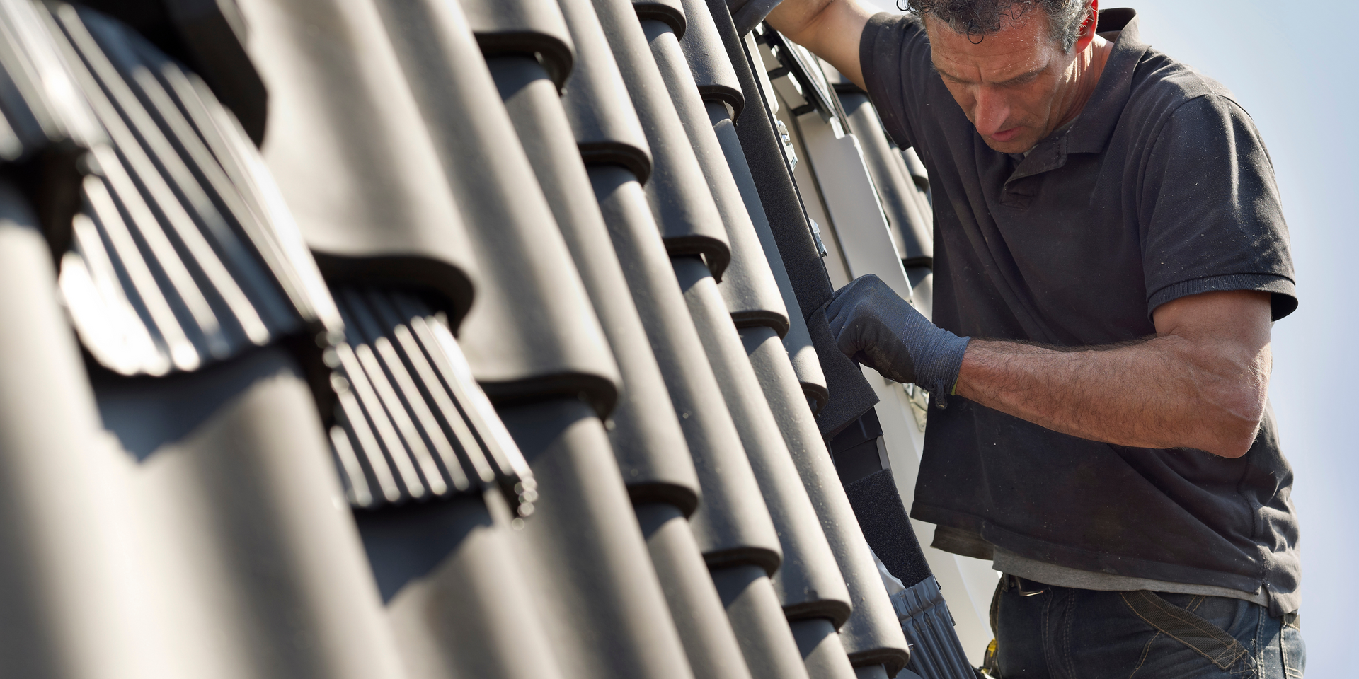 A man is working on a roof with a ladder.