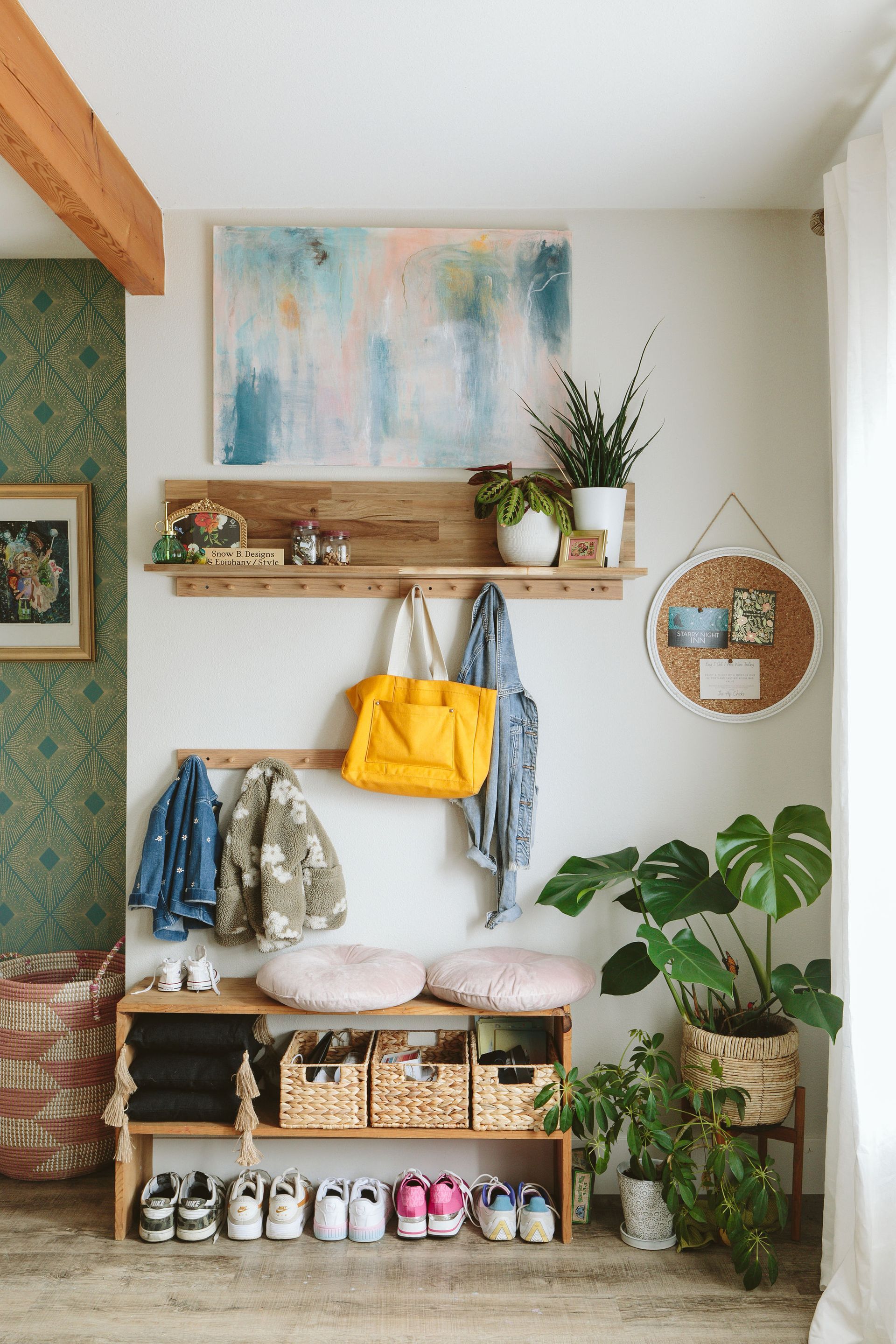 Styled entryway with wall hooks, wood shelf, and layered decor in a functional modern home