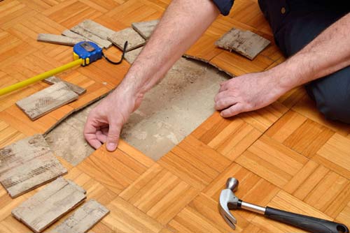 Man Removing Damaged Parquet - Remodeling in Burien, WA