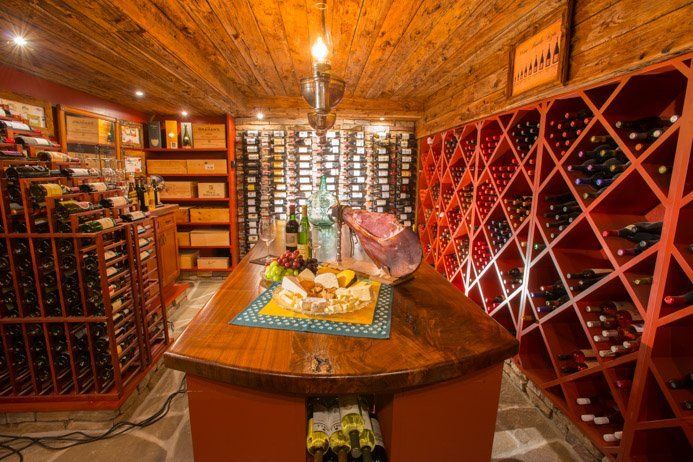A wine cellar filled with lots of wine bottles and a table.