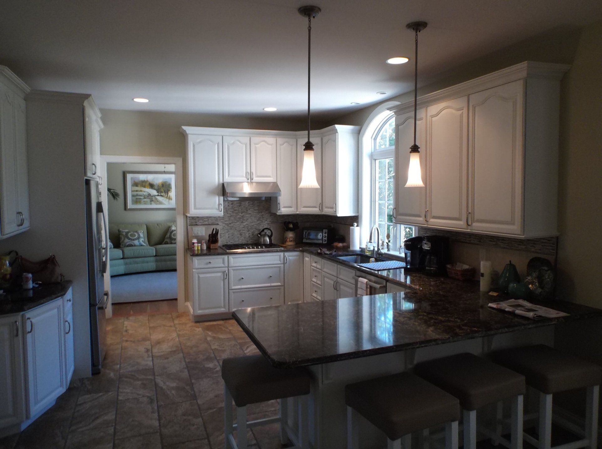 A kitchen with white cabinets and granite counter tops