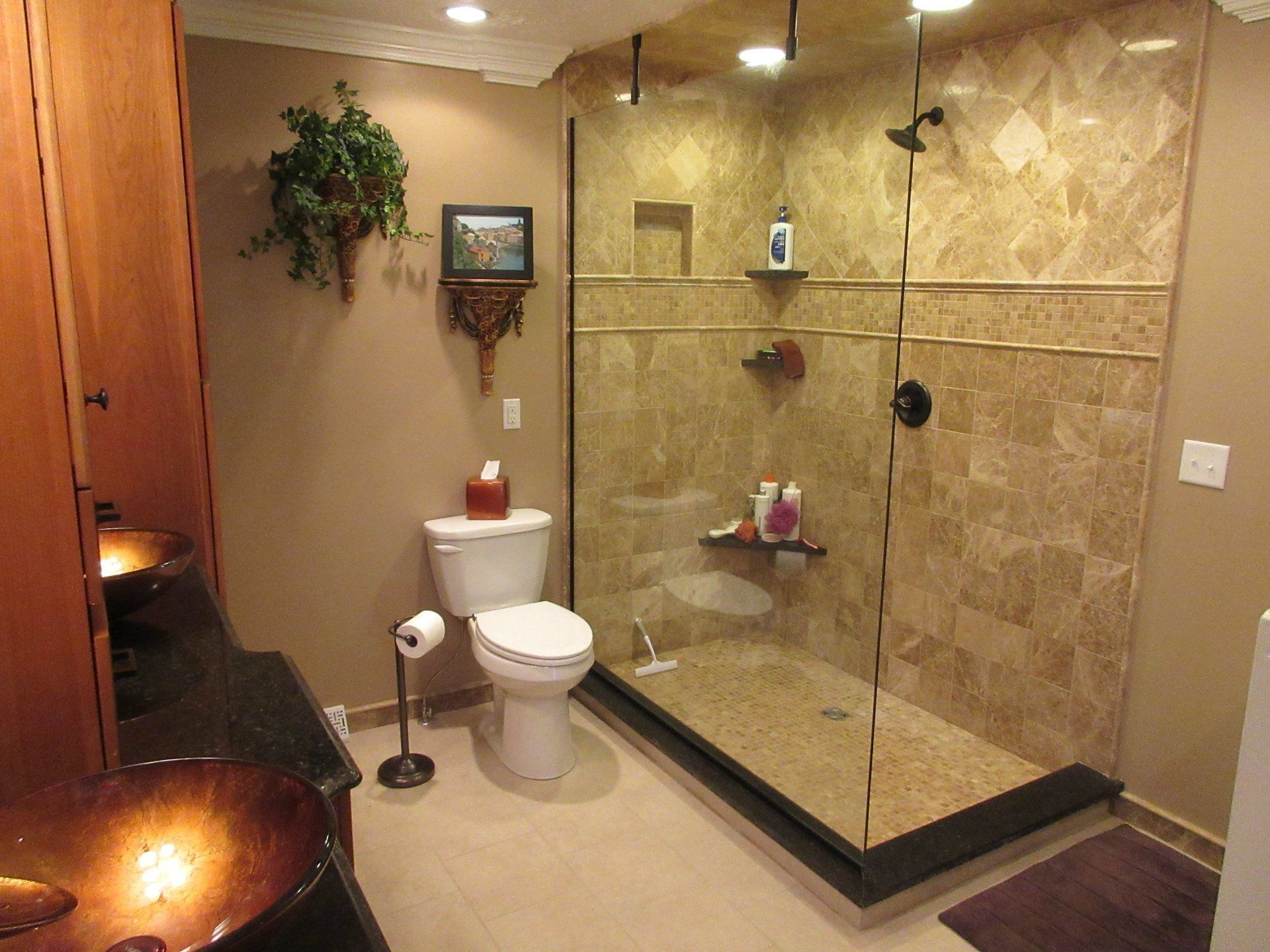 A bathroom with a toilet , sink and walk in shower.