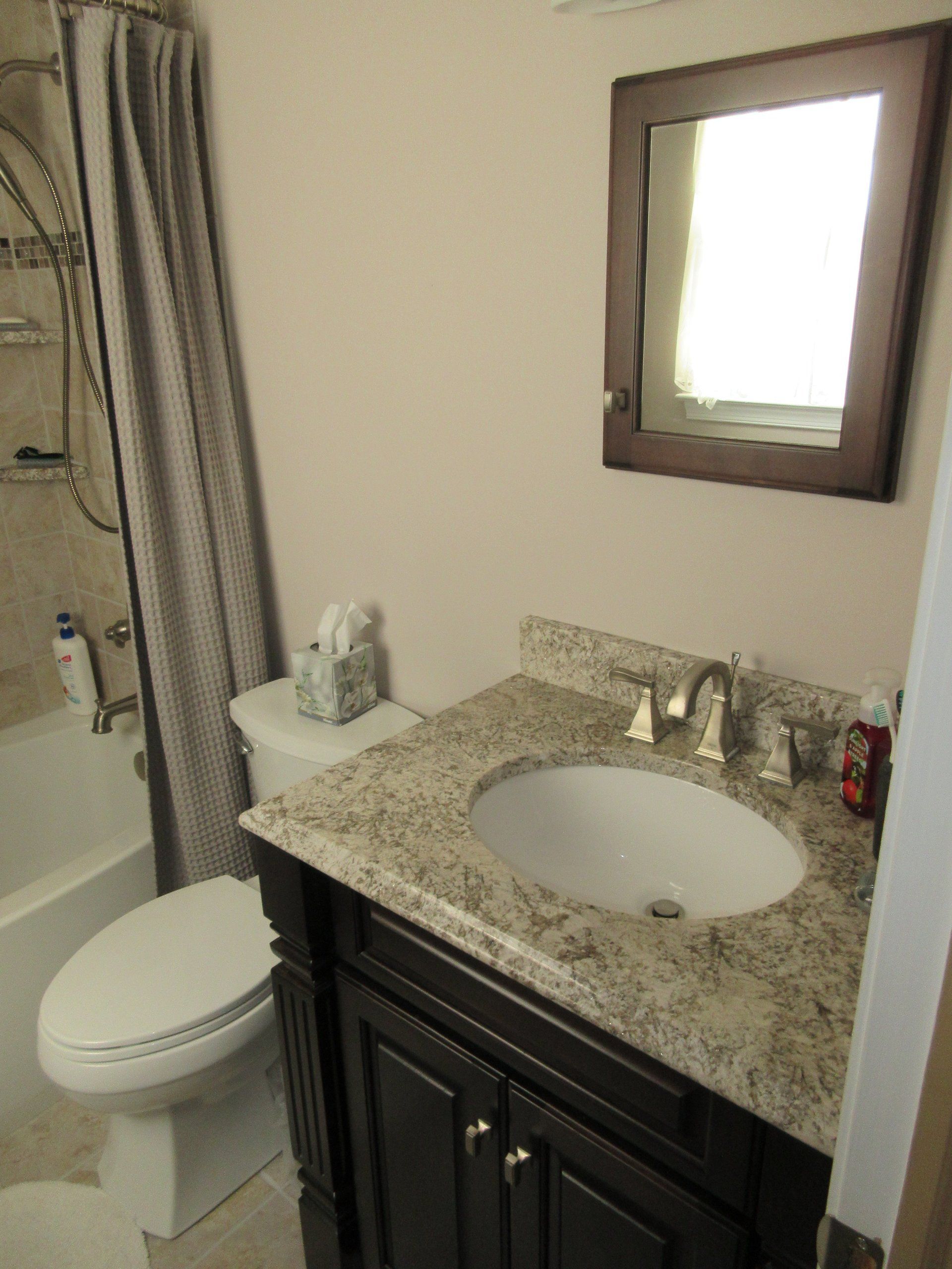 A bathroom with a toilet a sink and a mirror