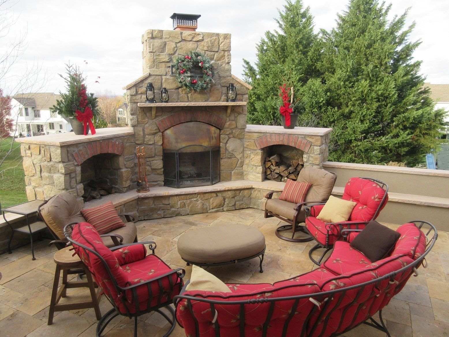 A patio with a fireplace and a couch and chairs