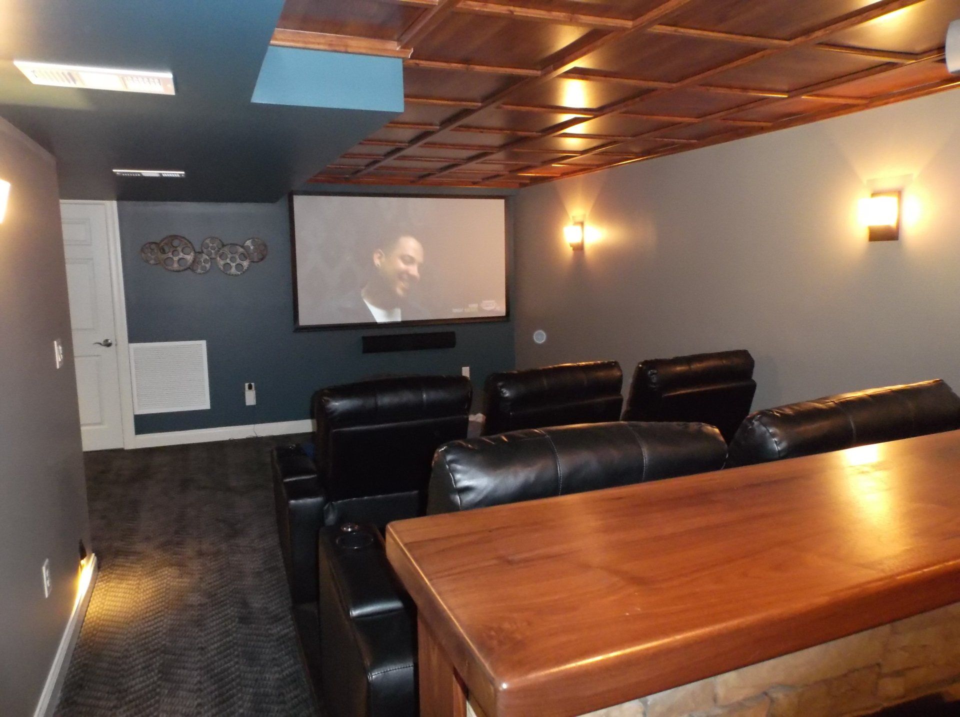 A home theater with black leather chairs and a large screen