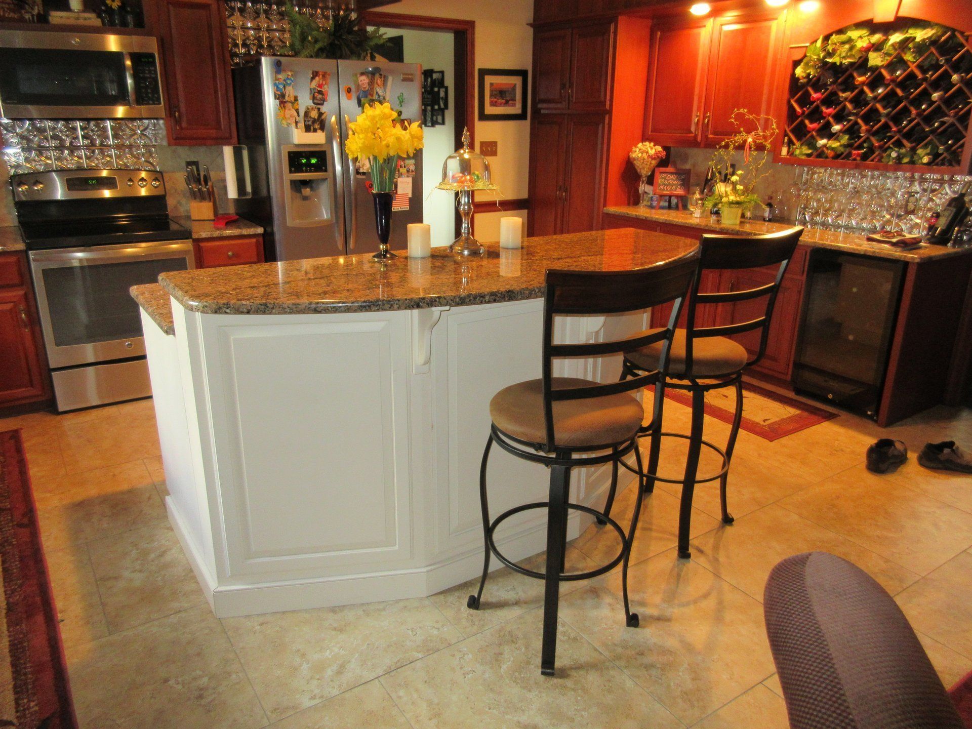 A kitchen with a large island and two chairs