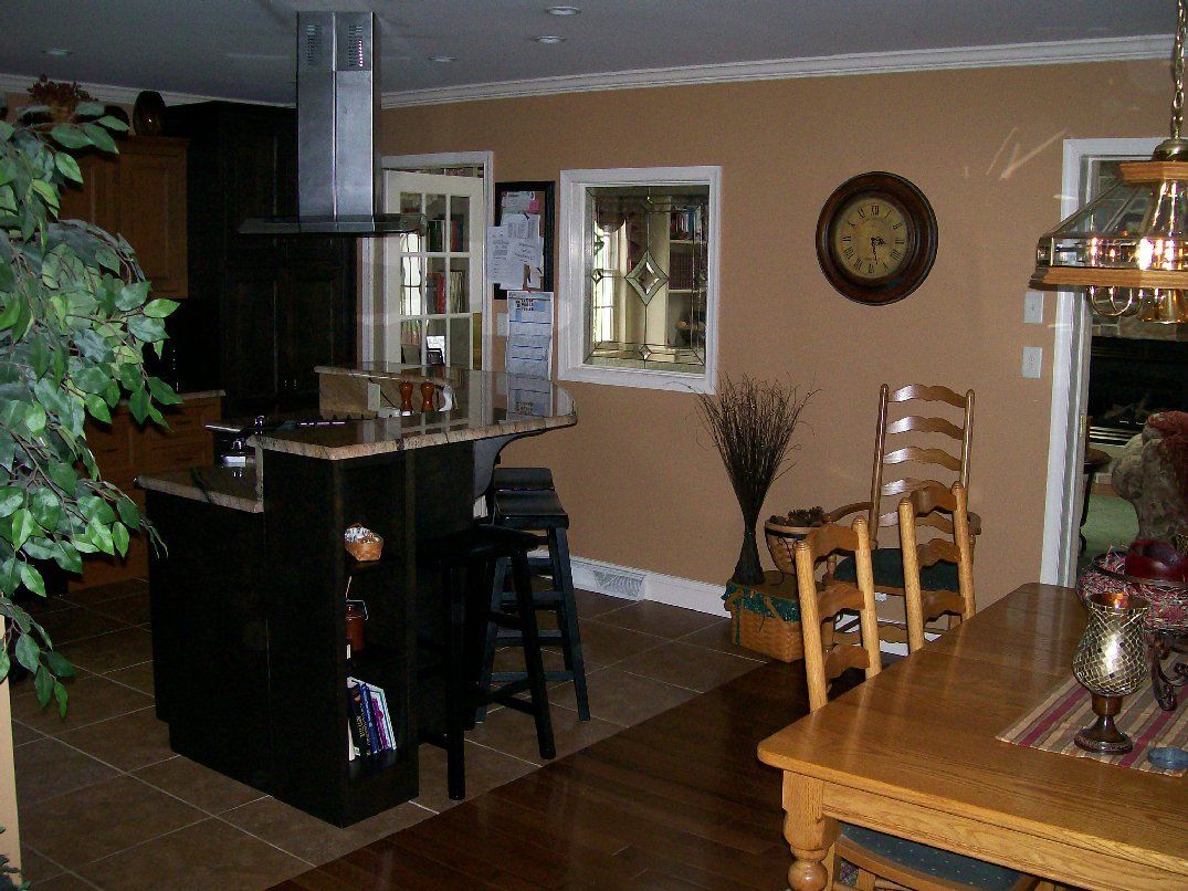 A kitchen with a table and chairs and a clock on the wall