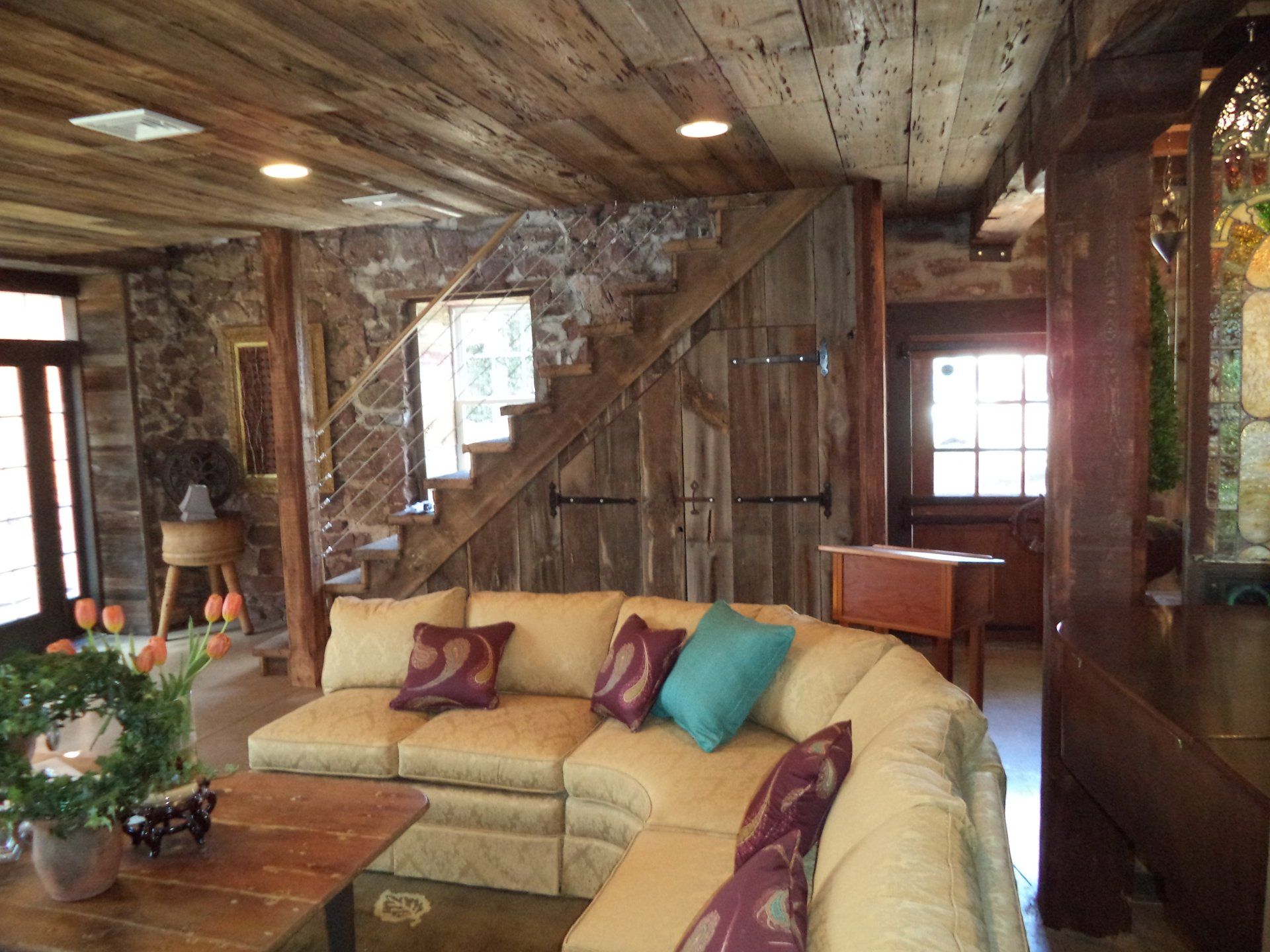 A living room with a sectional couch and stairs