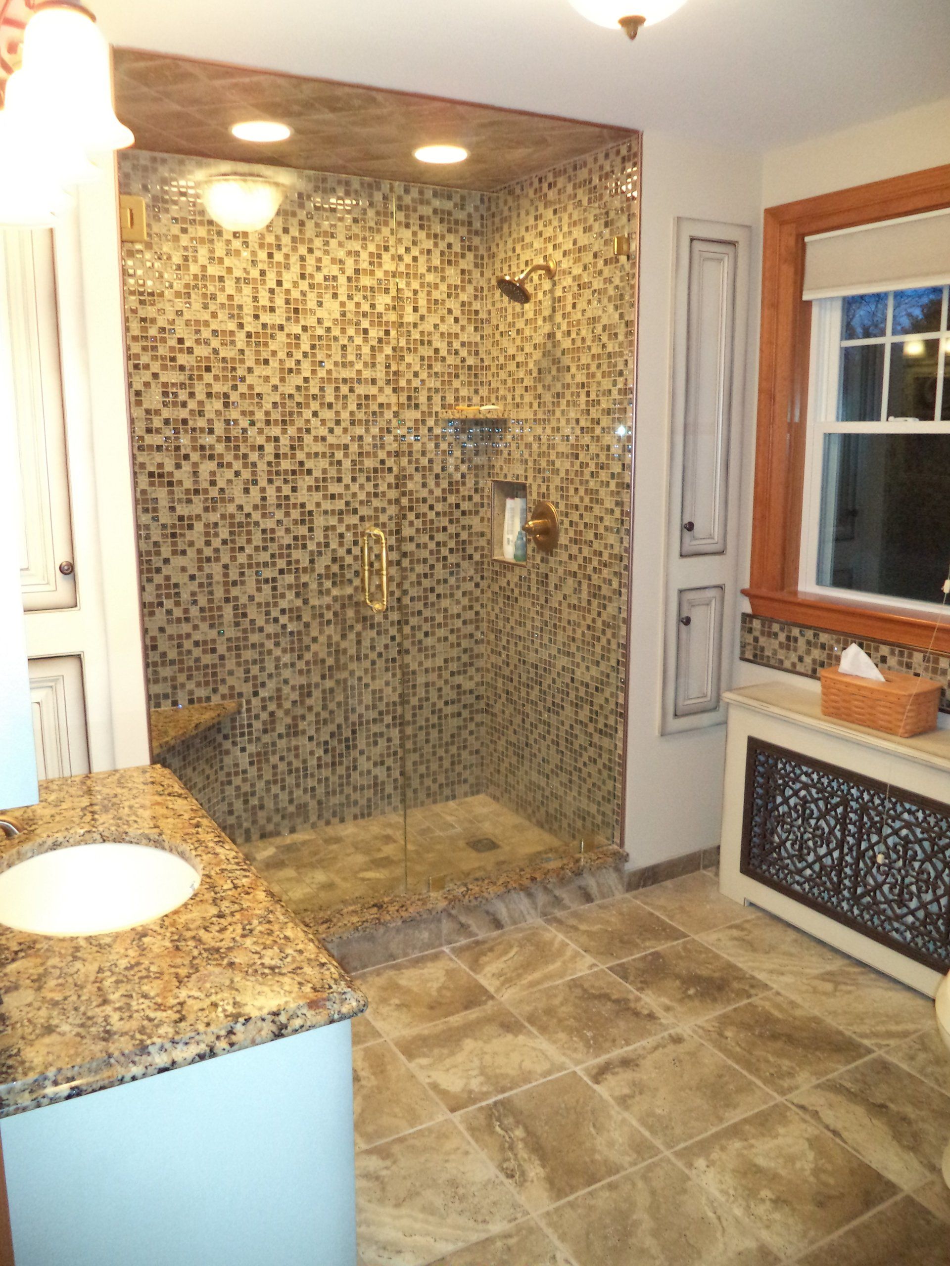 A bathroom with a walk in shower and a sink