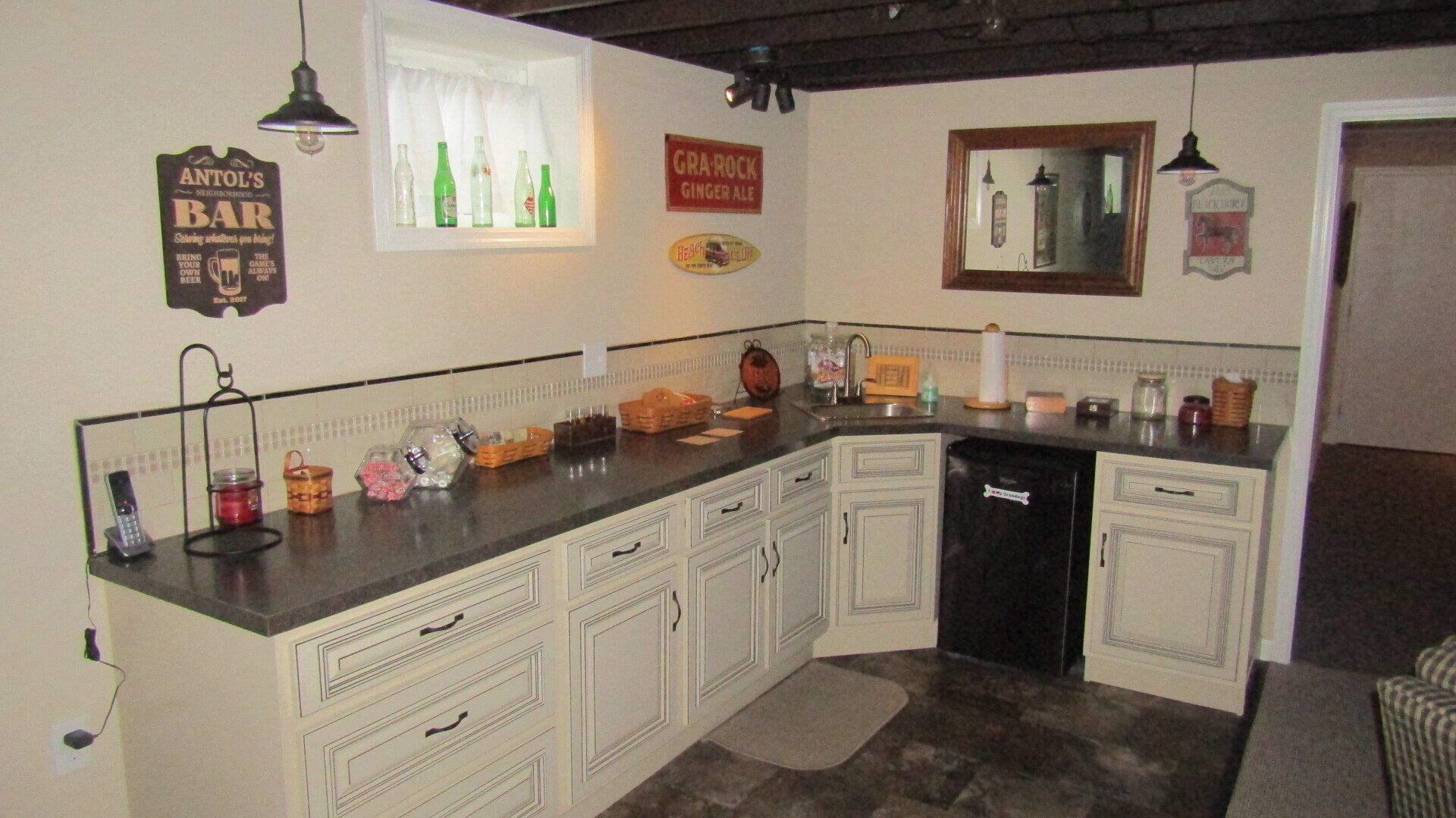 A kitchen with white cabinets and a sign that says bar