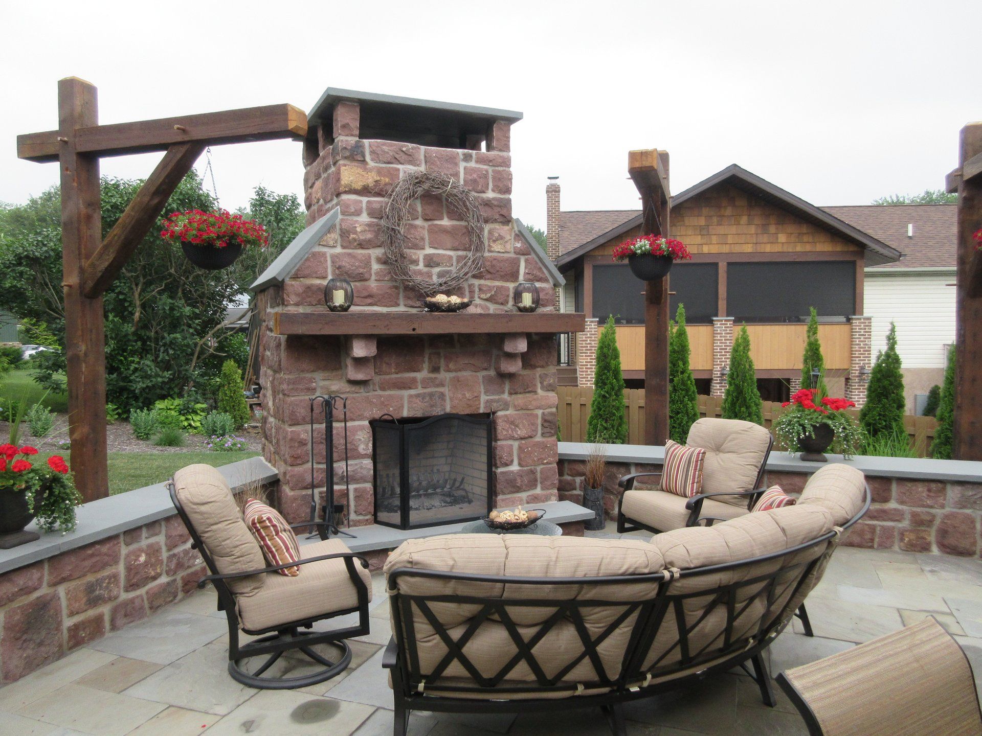A patio with a fireplace and a couch and chairs