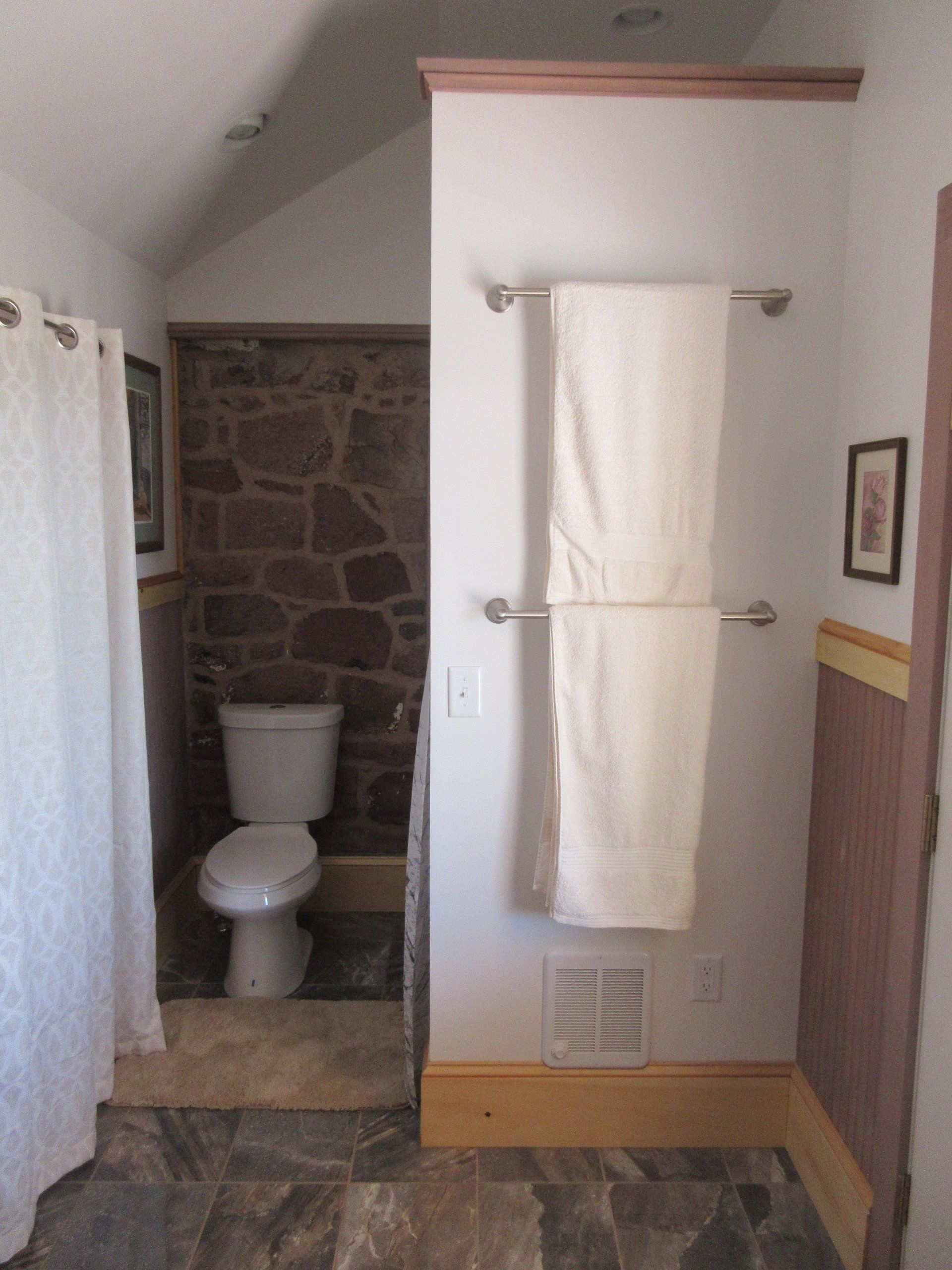 A bathroom with a toilet and a towel rack