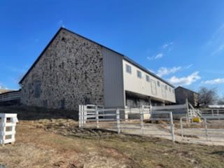 A large stone building with a fence around it and a blue sky in the background.