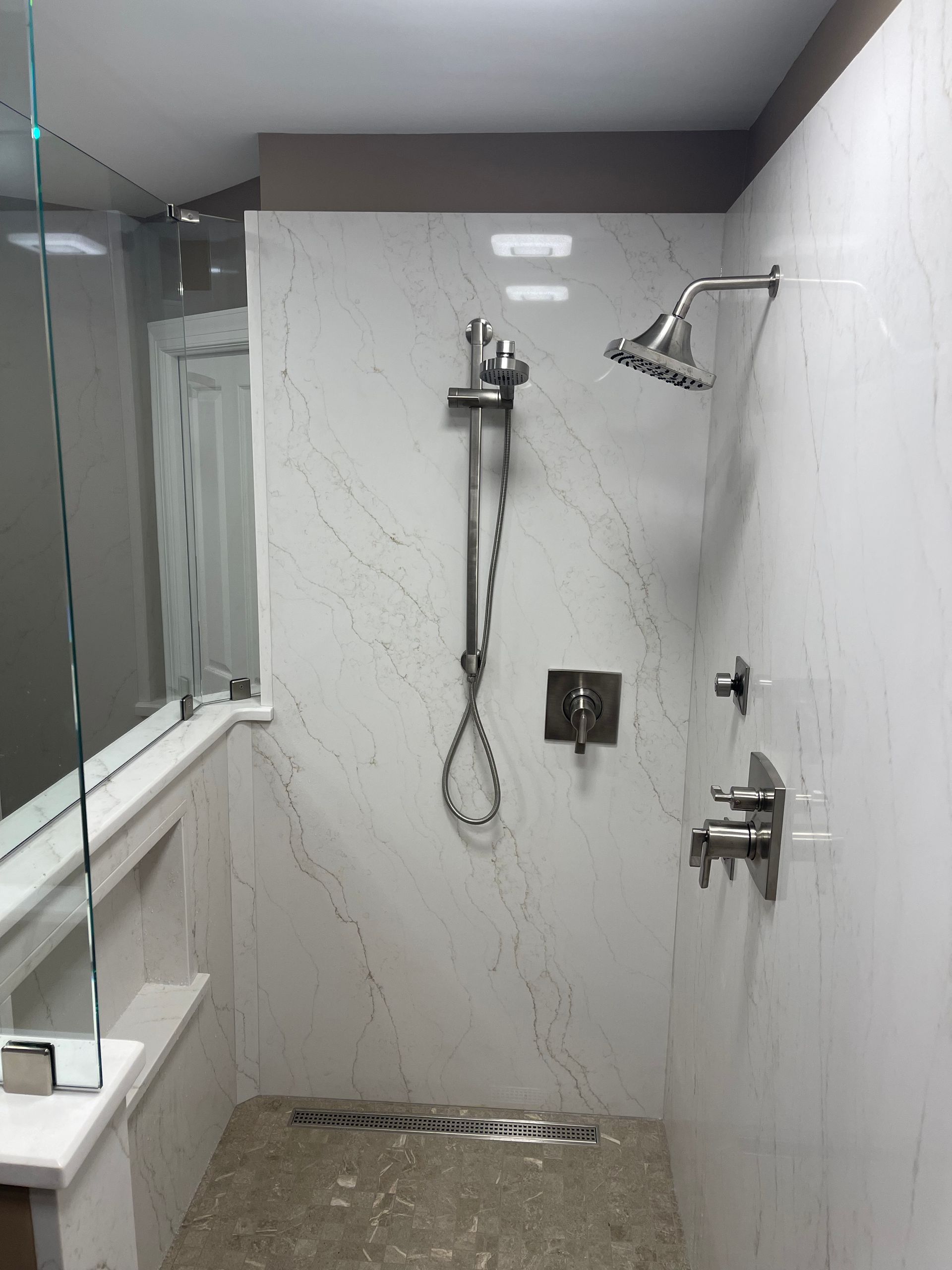 A bathroom with a walk in shower and a mirror