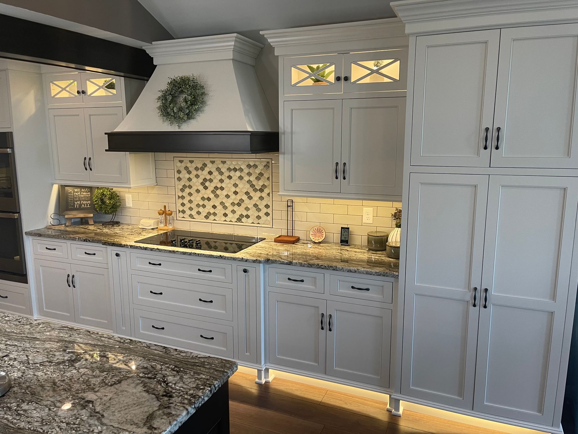 A kitchen with white cabinets and granite counter tops.
