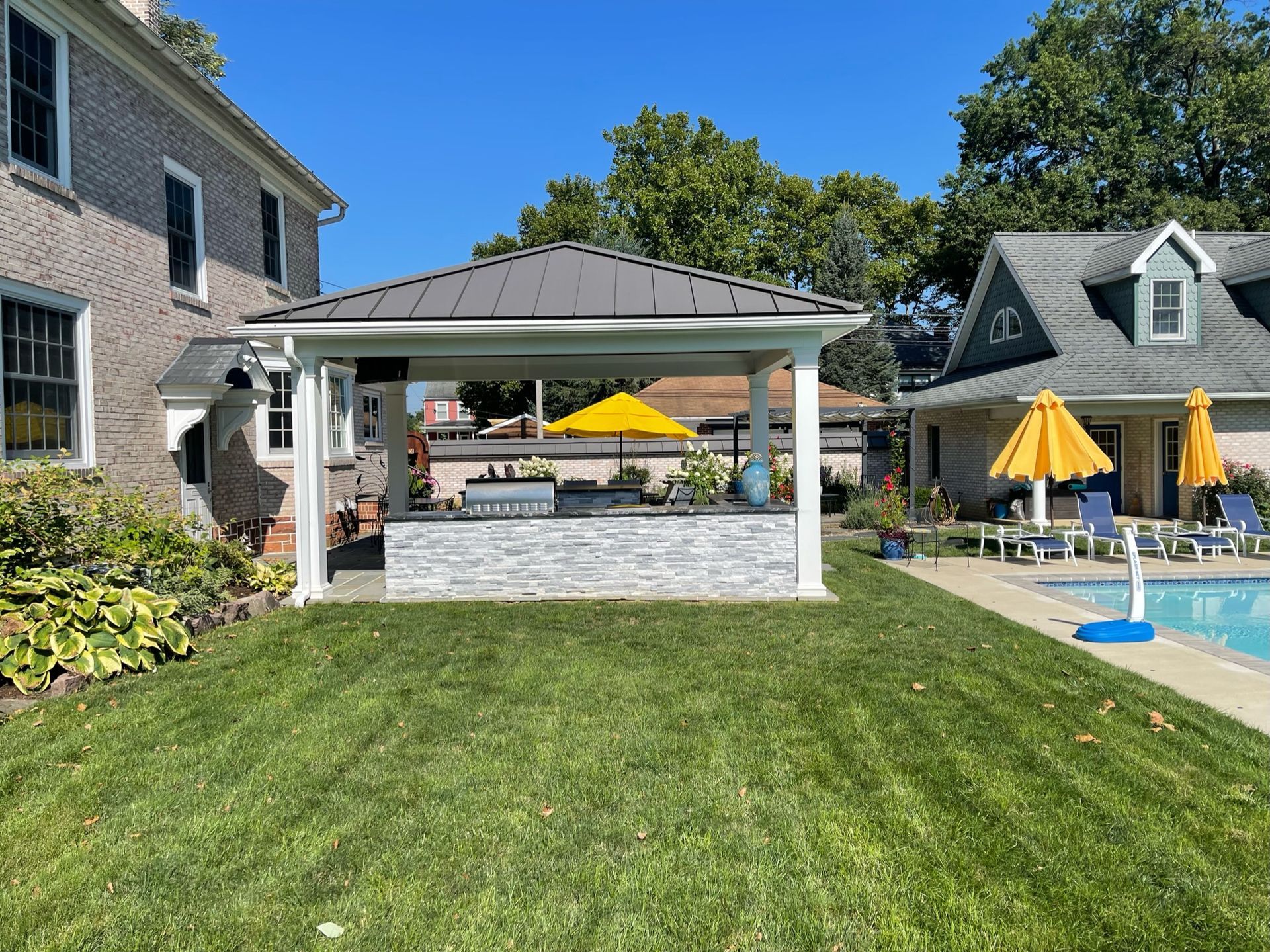 A house with a swimming pool and a pavilion in the backyard.