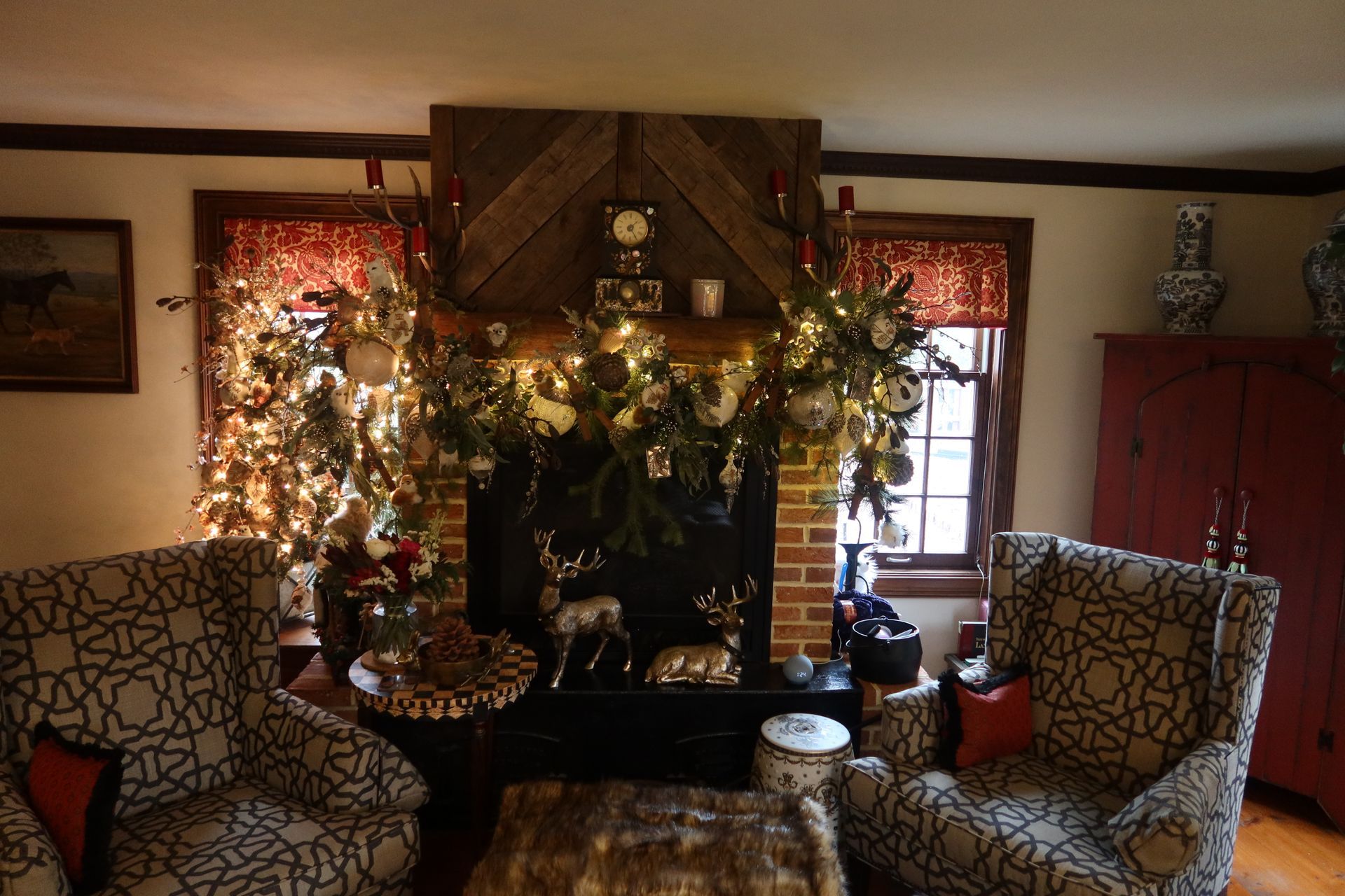 A living room with two chairs and a fireplace decorated for christmas