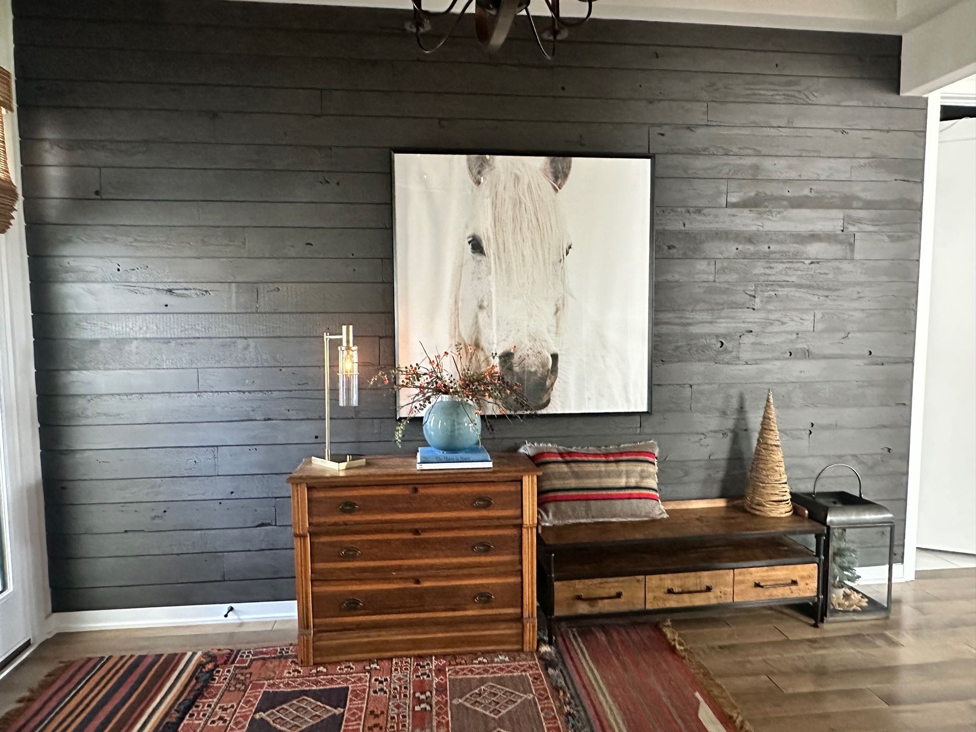 There is a painting of a horse on the wall above the dresser.