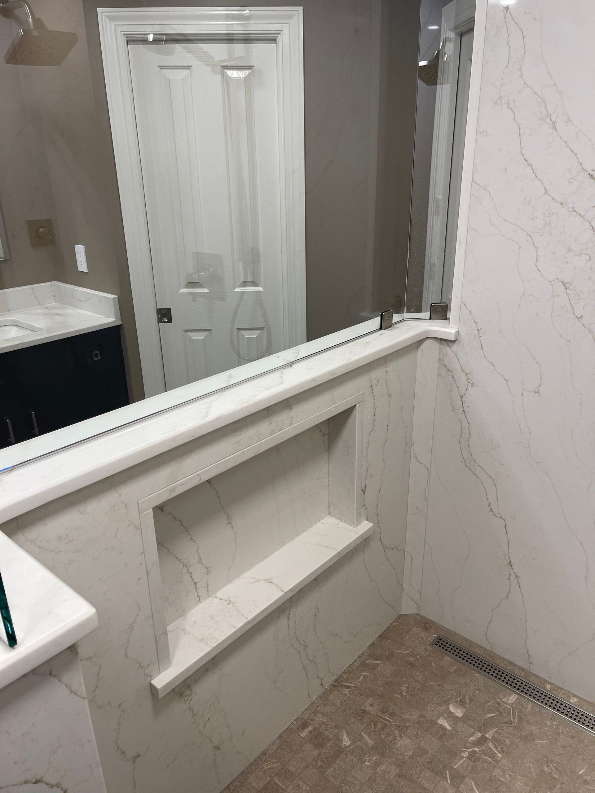 A bathroom with a large mirror and a shelf