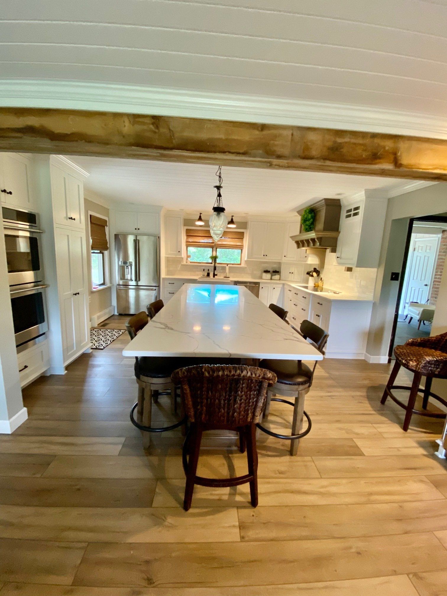A kitchen with a long table and chairs in it.