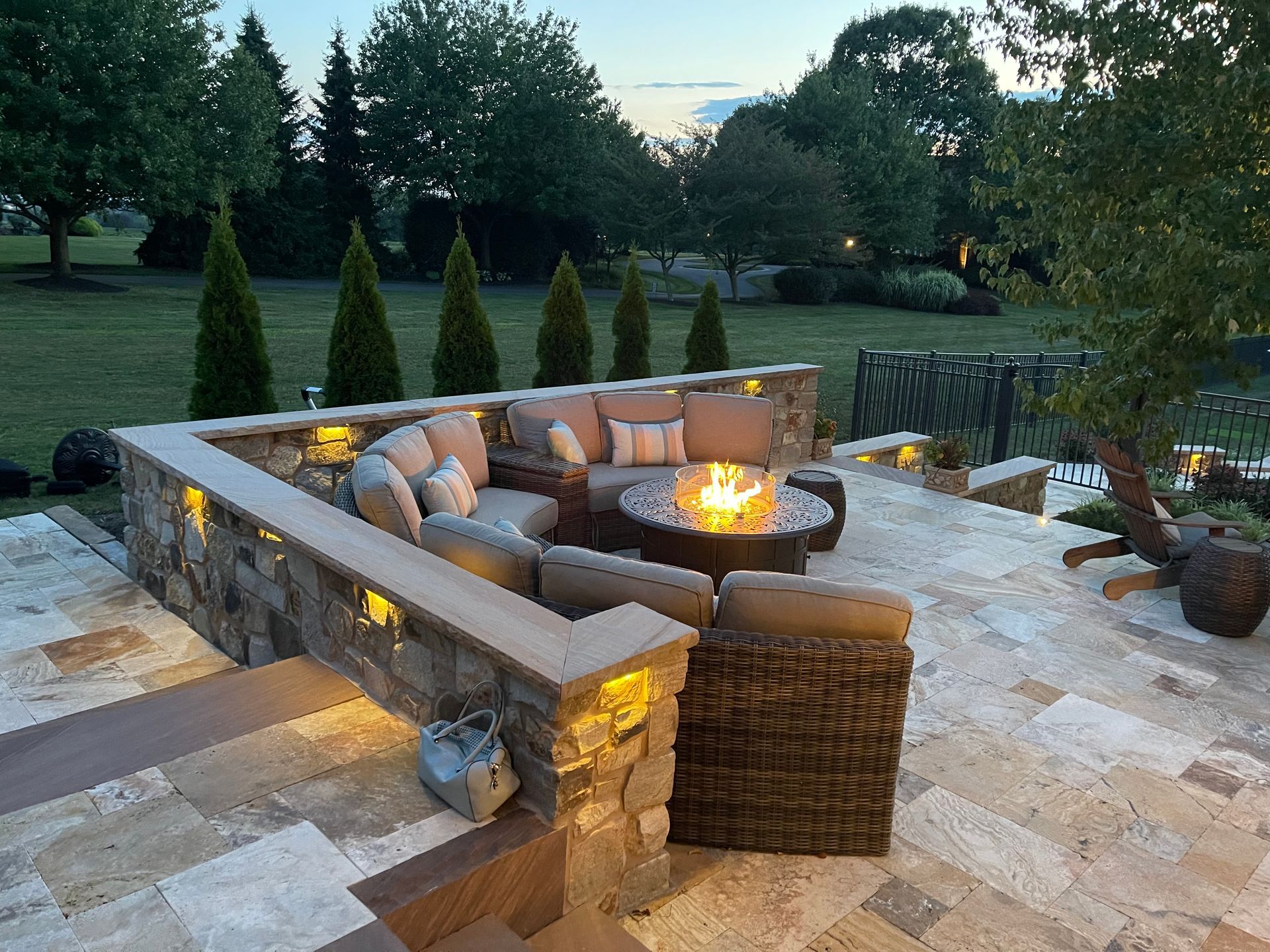 A patio with a fire pit and a sectional couch