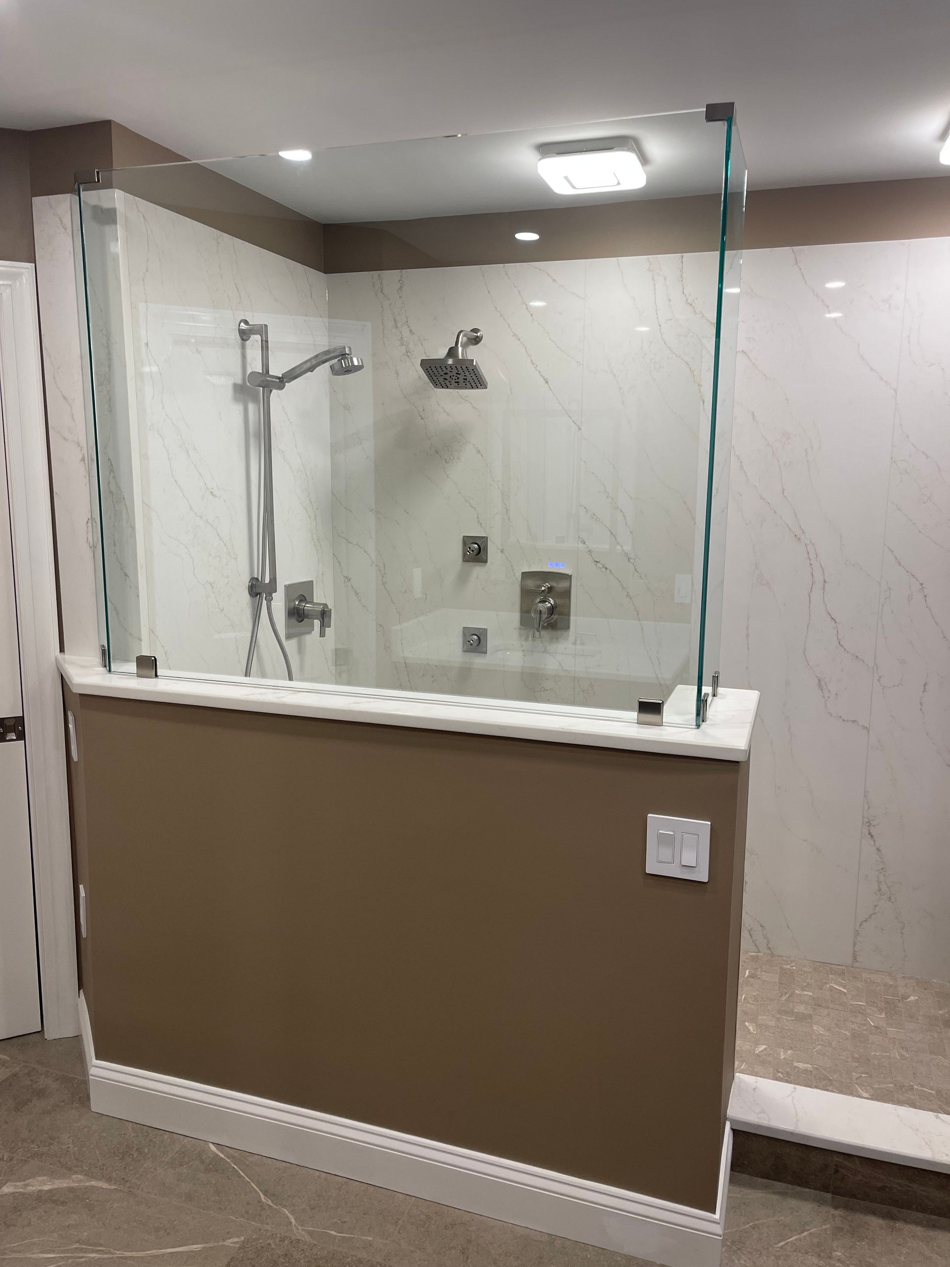 A bathroom with a walk in shower with a glass door