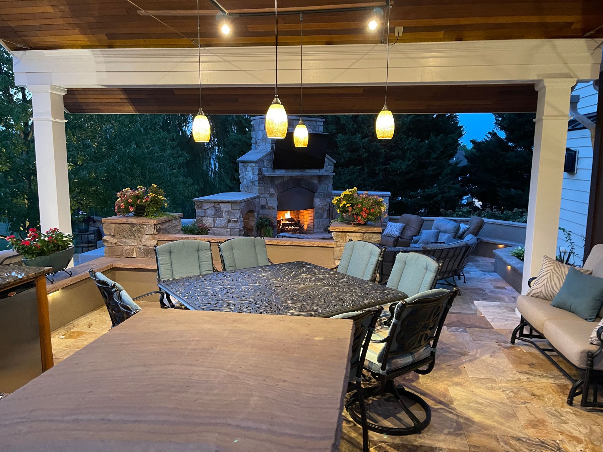 A patio with a table and chairs and a fireplace.